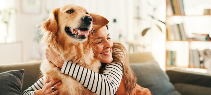a woman hugging her golden retriever dog