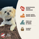 Dog lying on a brown blanket next to a product label for Wisconsin-made dog food with text about ingredients and production.