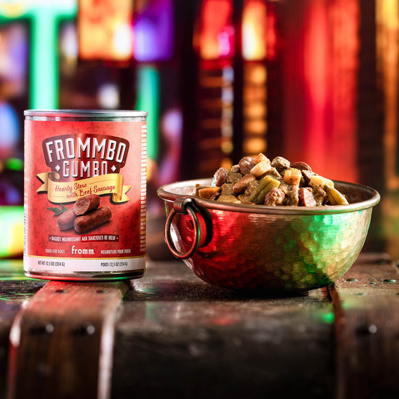 Can of Frommbo Gombo pet food next to a bowl of food on a colorful background