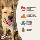 Dog standing next to a product label about Wisconsin-made sausage with bone broth, suitable for all breeds and ages.