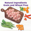 Diced chicken on a wooden cutting board with vegetables and text 'Natural Ingredients Grain and Wheat Free' on a light background.