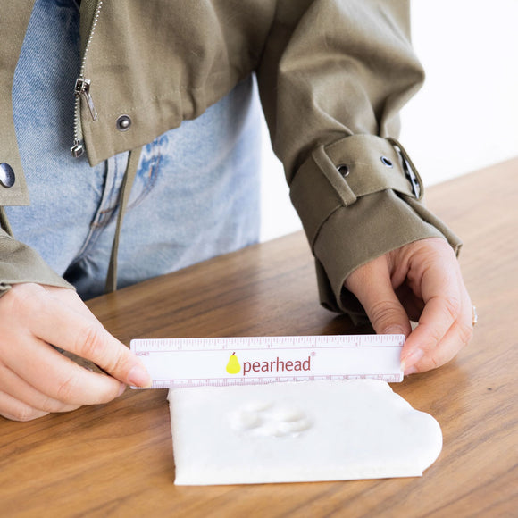 Person holding a Pearhead product on a wooden surface