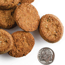 Dog treats stacked with a quarter for scale on a white background