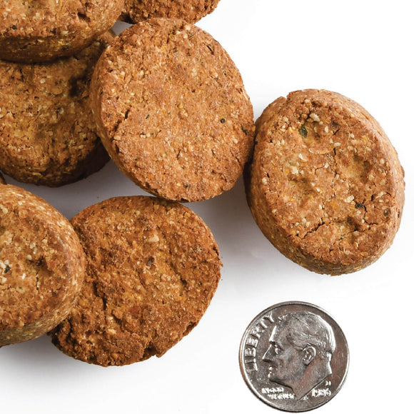 Dog treats stacked with a quarter for scale on a white background