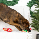 Dog playing with a toy in front of a Christmas tree