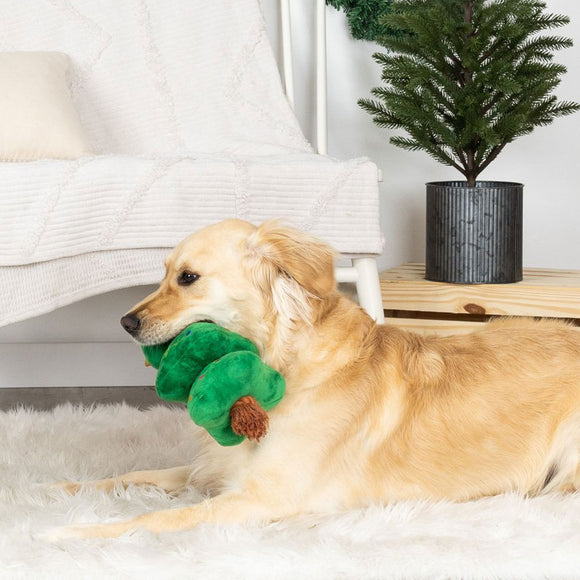 Dog playing with a green toy on a white rug