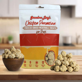 Bag of Grandma Lucy's Chicken Parmesan freeze-dried meatball treats for dogs on a kitchen counter with treats displayed.