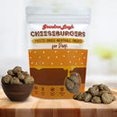 Package of Grandma Lucy's Cheeseburgers freeze-dried meatball treats for dogs on a wooden surface with treats around.