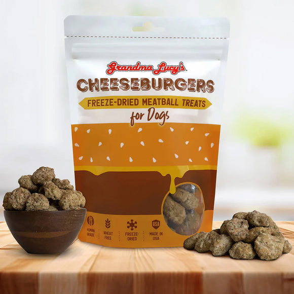 Package of Grandma Lucy's Cheeseburgers freeze-dried meatball treats for dogs on a wooden surface with treats around.