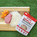 Package of Simple Replacement on a cutting board with meat, rice, and pumpkin.