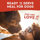 Man lying on the ground next to a dog with text 'Ready to serve meal for dogs, just add love' on a red background.
