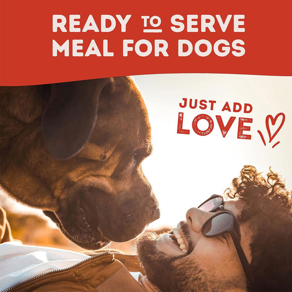Man lying on the ground next to a dog with text 'Ready to serve meal for dogs, just add love' on a red background.