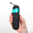 Black pepper spray container with teal component held by a hand on a white background