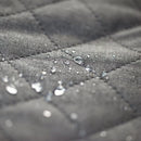 Close-up of water droplets on a textured gray fabric surface