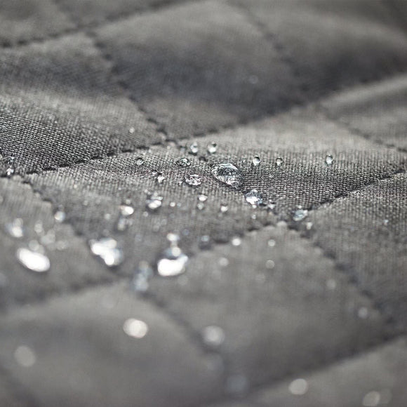 Close-up of water droplets on a textured gray fabric surface