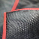 Close-up of black perforated material with red border
