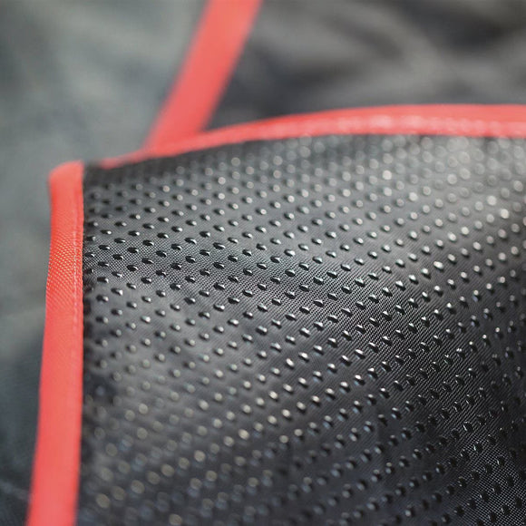 Close-up of black perforated material with red border