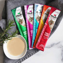 Nulo Freestyle cat food pouches with a bowl of cat food on a marble surface.