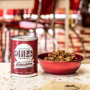 Can of Fromm Diner Beef Barkundy Stew on a table with a bowl of food in a diner setting.