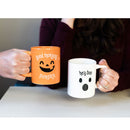 Two mugs with Halloween-themed text and graphics held by two people.