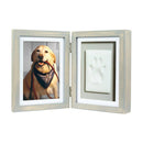 Double picture frame with a photo of a dog on one side and a paw print on the other, on a white background.