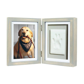 Double picture frame with a photo of a dog on one side and a paw print on the other, on a white background.