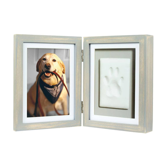 Double picture frame with a photo of a dog on one side and a paw print on the other, on a white background.