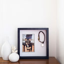 Framed photo of a dog with a dog collar on a wooden surface