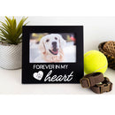 Black photo frame with a dog picture and 'Forever in my heart' text, next to a tennis ball and dog collar.