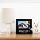 Decorative photo album with a dog picture and 'Forever Loved' text on a table.