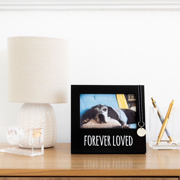 Decorative photo album with a dog picture and 'Forever Loved' text on a table.