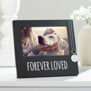 Black photo frame with 'Forever Loved' text, holding a photo of a person petting a dog, on a white surface.