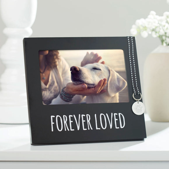 Black photo frame with 'Forever Loved' text, holding a photo of a person petting a dog, on a white surface.