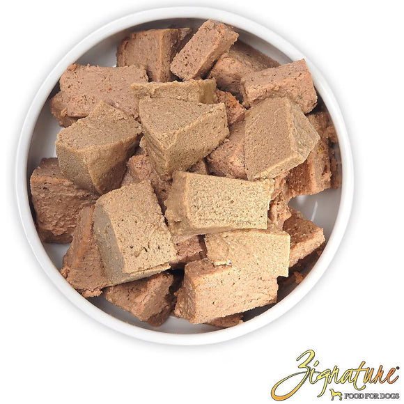 Dog treats in a white bowl with 'Zignature' branding.