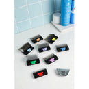 Set of hair clipper attachments on a bathroom counter with blue tiles in the background.