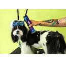 Dog being groomed with a hair clipper against a green background