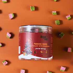 Jar of freeze-dried cat grass with cranberry on an orange background