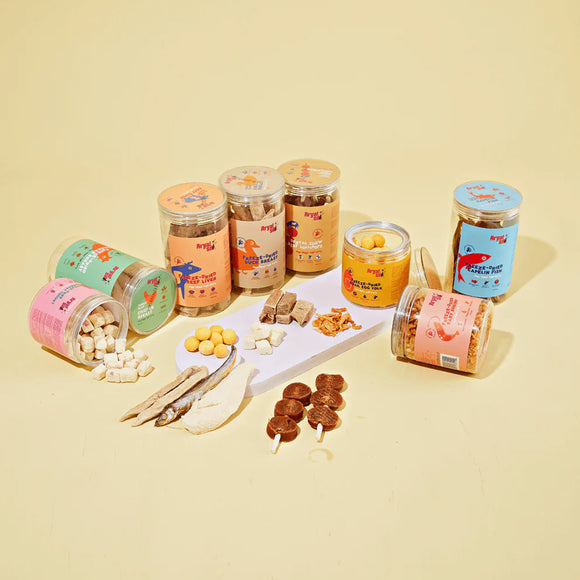 Assorted pet treats in jars and containers on a beige background