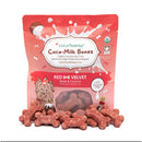 Red velvet dog treats with 'CocoTherapy Coco-Milk Bones' packaging on a white background
