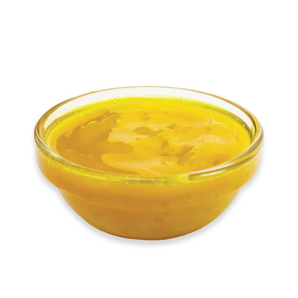 Clear glass bowl filled with yellow liquid on a white background
