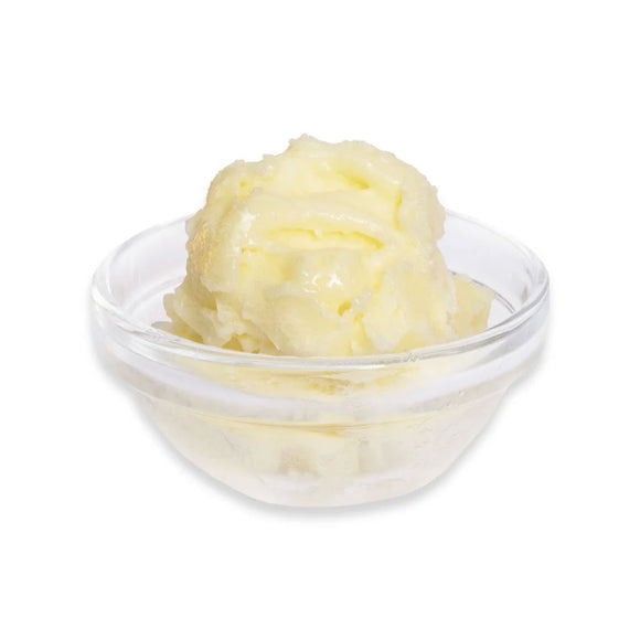 Glass bowl with yellow butter on a white background