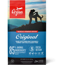 Orijen dog food package with a silhouette of a person and dog on a mountain, set against a blue sky.