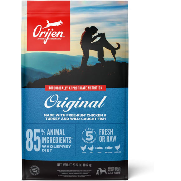 Orijen dog food package with a silhouette of a person and dog on a mountain, set against a blue sky.