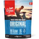 Orijen freeze-dried dog treats packaging with a sunset scene and silhouette of a person and dog.