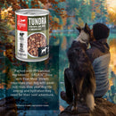 Orijen Tundra can of dog food with a person and dog by a lake