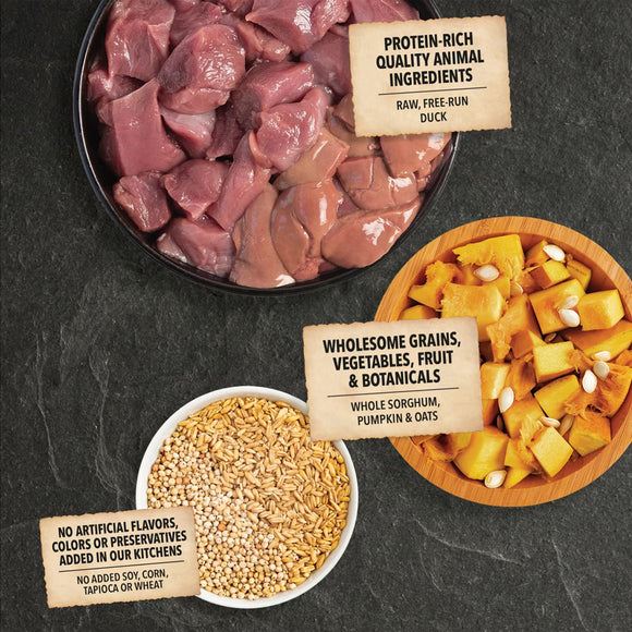 Raw pet food ingredients including duck, grains, vegetables, and a label on a dark surface.