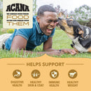 Man lying on grass with a dog, promoting Acana pet food benefits.