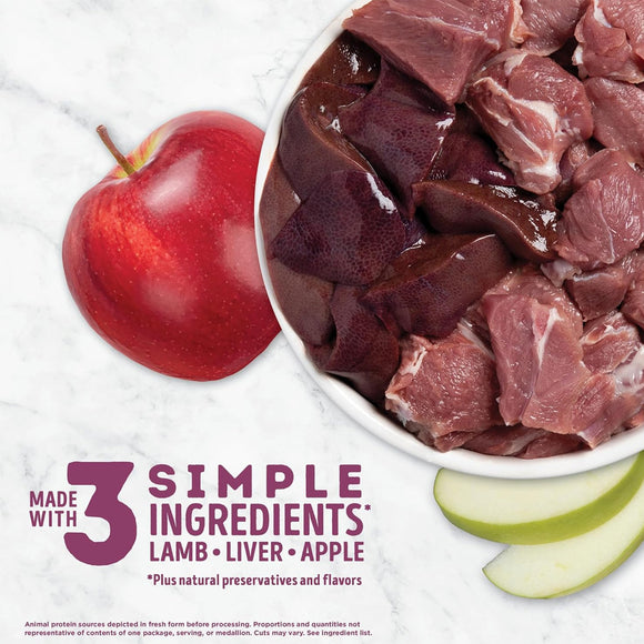 Raw lamb, liver, and apple in a bowl with an apple on the side on a white background.