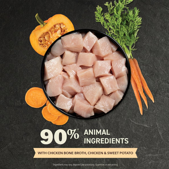 Raw chicken pieces in a bowl with vegetables on a dark background, highlighting 90% animal ingredients.