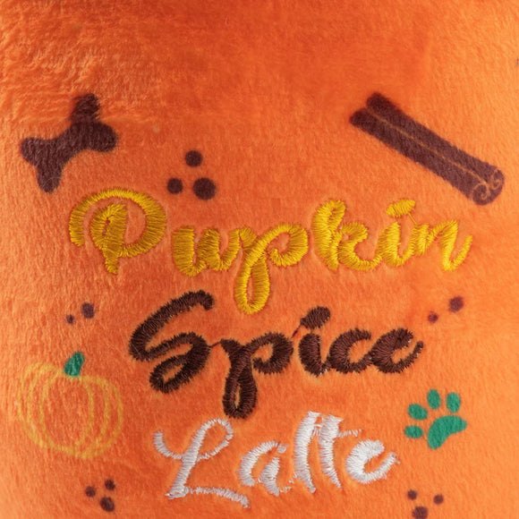 Embroidered text 'Pumpkin Spice Latte' on an orange fabric background with pumpkin, cinnamon stick, and paw print designs.